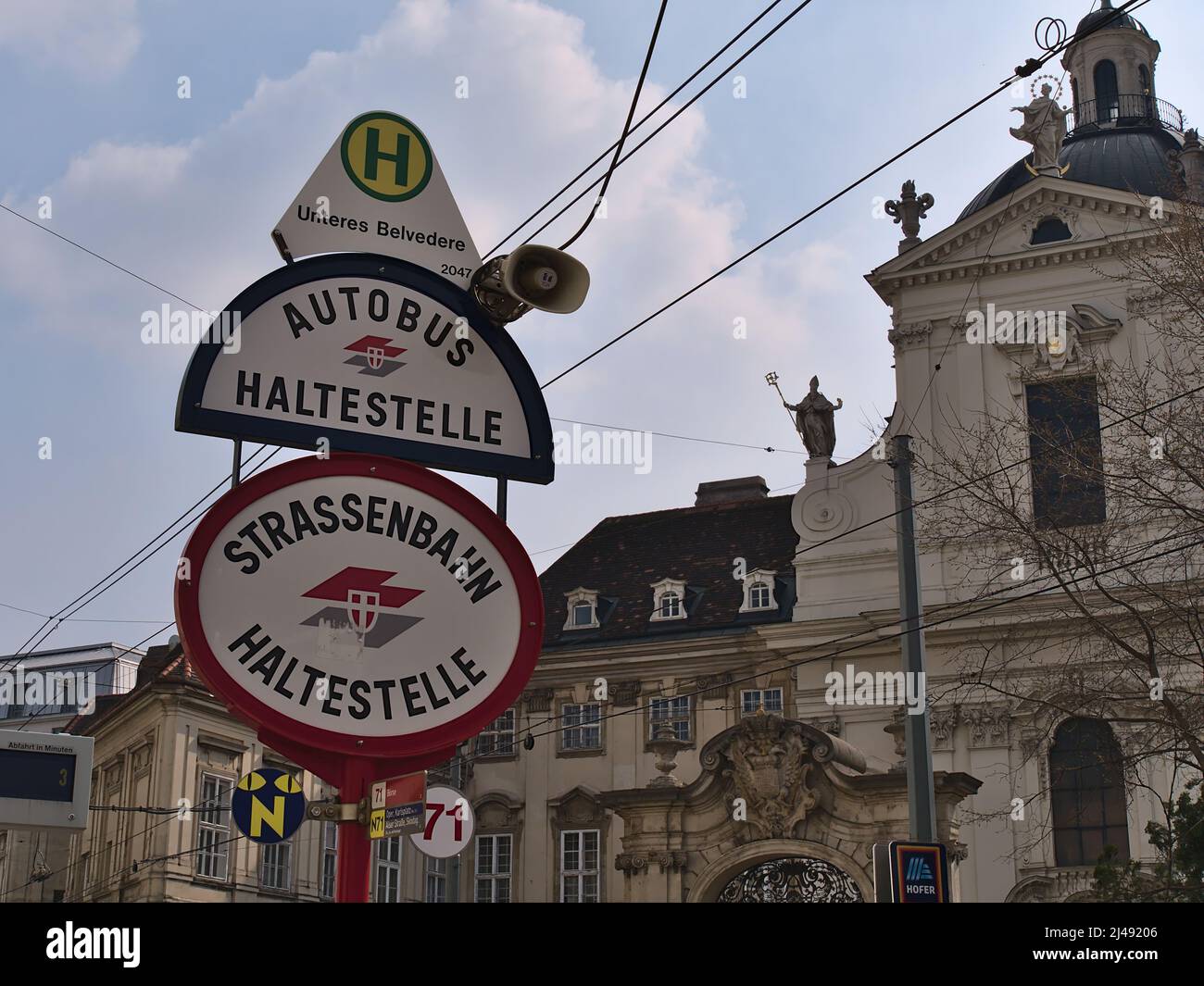 Straßenschilder an der Bus- und Straßenbahnhaltestelle Unteres Belvedere in der historischen Innenstadt von Wien, Österreich mit dem Logo der Wiener Linien und Altbau. Stockfoto