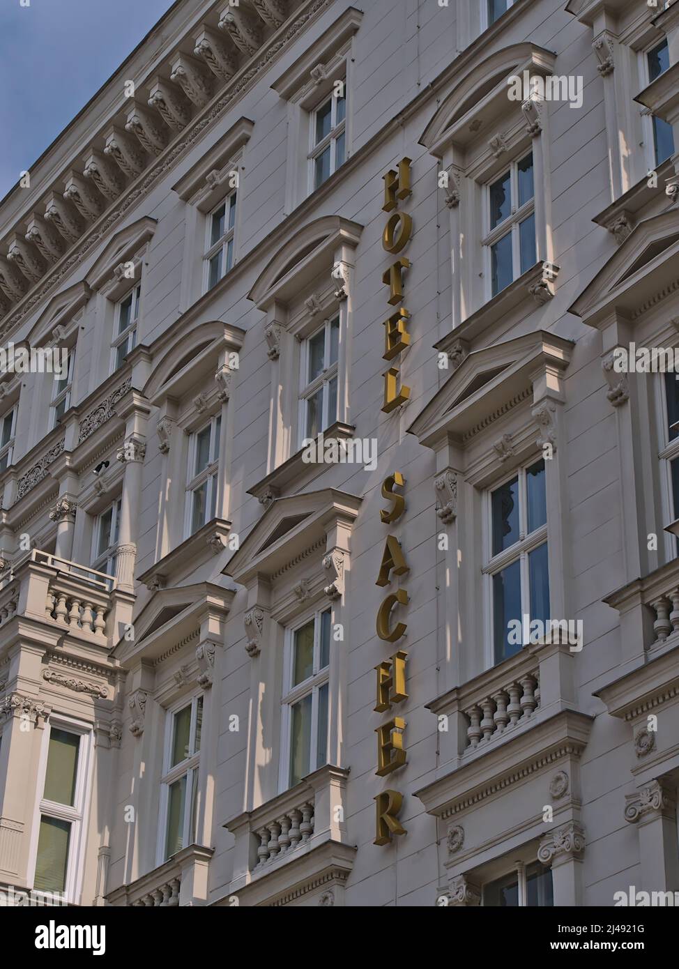 Low-Angle-Ansicht der dekorativen Fassade des berühmten Luxus-Hotels Sacher im historischen Zentrum von Wien, Österreich mit Schriftzug. Stockfoto