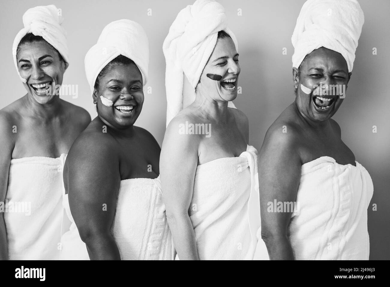Frauen mit mehreren Generationen und verschiedenem Körper lachen zusammen, während sie Körperhandtücher tragen - Fokus auf kaukasisches weibliches Gesicht - Schwarzes und weißes Leitbild Stockfoto
