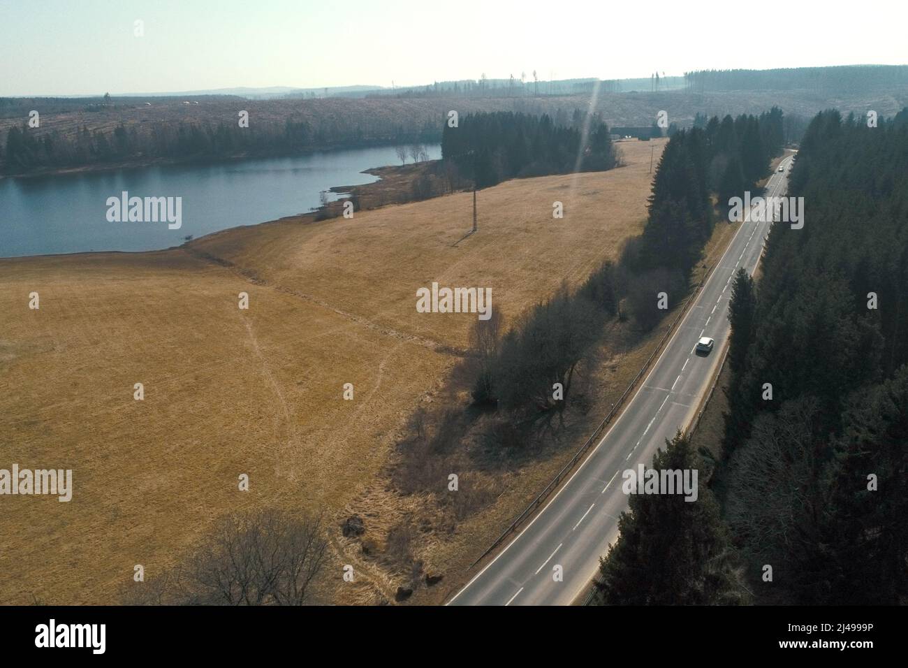 25. März 2022, Sachsen-Anhalt, Königshütte: Blick auf einen 1.200 Meter langen Abschnitt entlang des Staudamms bei Mandelholz. Freiwillige sind damit beschäftigt, einen Krötenzaun entlang einer Straße zwischen Königshütte und Mandelholz im Harz zu errichten. Nun beginnen vor allem die Kröten ihre Migration. Durch die milden Temperaturen der letzten Tage werden diese Tiere langsam wieder aktiv. Sobald die Nachttemperaturen nicht mehr unter sechs Grad fallen, beginnen die Kröten, Kröten, Molche, Salamander und Frösche ihre Frühjahrswanderung in ihre angestammten Laichgewässer. (Aufgenommen mit einer Drohne) Foto: Matth Stockfoto