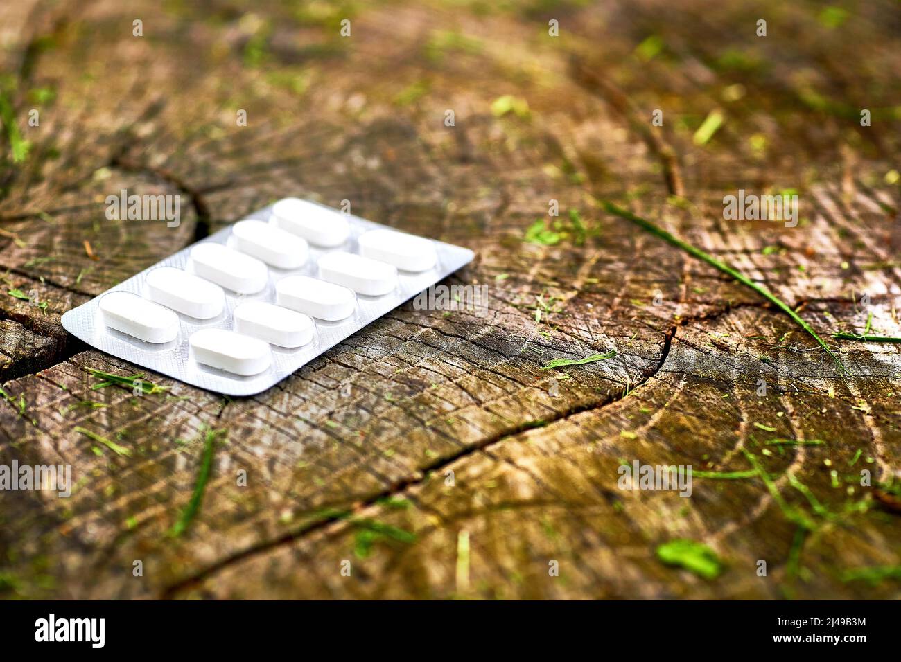 Orangefarbene rote Pillen in Blasen auf einem rosa Hintergrund. Stockfoto