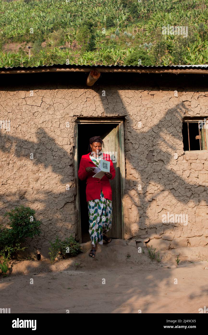 Genevieve, Manishimwe, 40, Dorf Nyange, Murambi-Zelle, Gakenke disrict. Ihr Mann wurde beim Völkermord getötet, sie hat vier Kinder, darunter Diane, 7 Jahre alt. Sie ist HIV-positiv. Bevor sie sich dem Programm anschloss, zog sie von Ort zu Ort, weil sie kein Haus hatte und oft hungrig war. Mit dem Erlös ihrer Landwirtschaft nach dem Training aus dem Programm hat sie sich nun ein Haus gebaut. Sie kaufte drei Parzellen Land, eine Kuh und zwei Schweine. Foto von Mike Goldwater Stockfoto