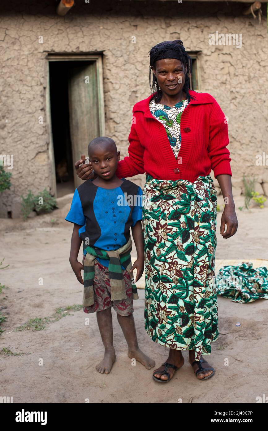 Genevieve, Manishimwe, 40, Dorf Nyange, Murambi-Zelle, Gakenke disrict. Ihr Mann wurde beim Völkermord getötet, sie hat vier Kinder, darunter Diane, 7 Jahre alt. Sie ist HIV-positiv. Bevor sie sich dem Programm anschloss, zog sie von Ort zu Ort, weil sie kein Haus hatte und oft hungrig war. Mit dem Erlös ihrer Landwirtschaft nach dem Training aus dem Programm hat sie sich nun ein Haus gebaut. Sie kaufte drei Parzellen Land, eine Kuh und zwei Schweine. Foto von Mike Goldwater Stockfoto