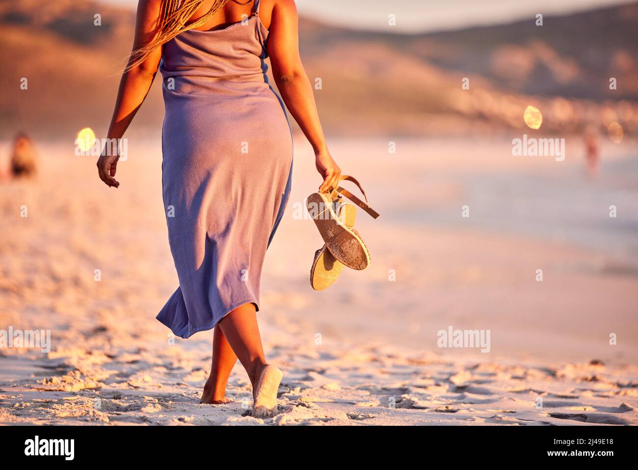 Die Verbesserung beginnt mit I. Rückansicht einer unkenntlichen Frau, die am Strand entlang läuft. Stockfoto