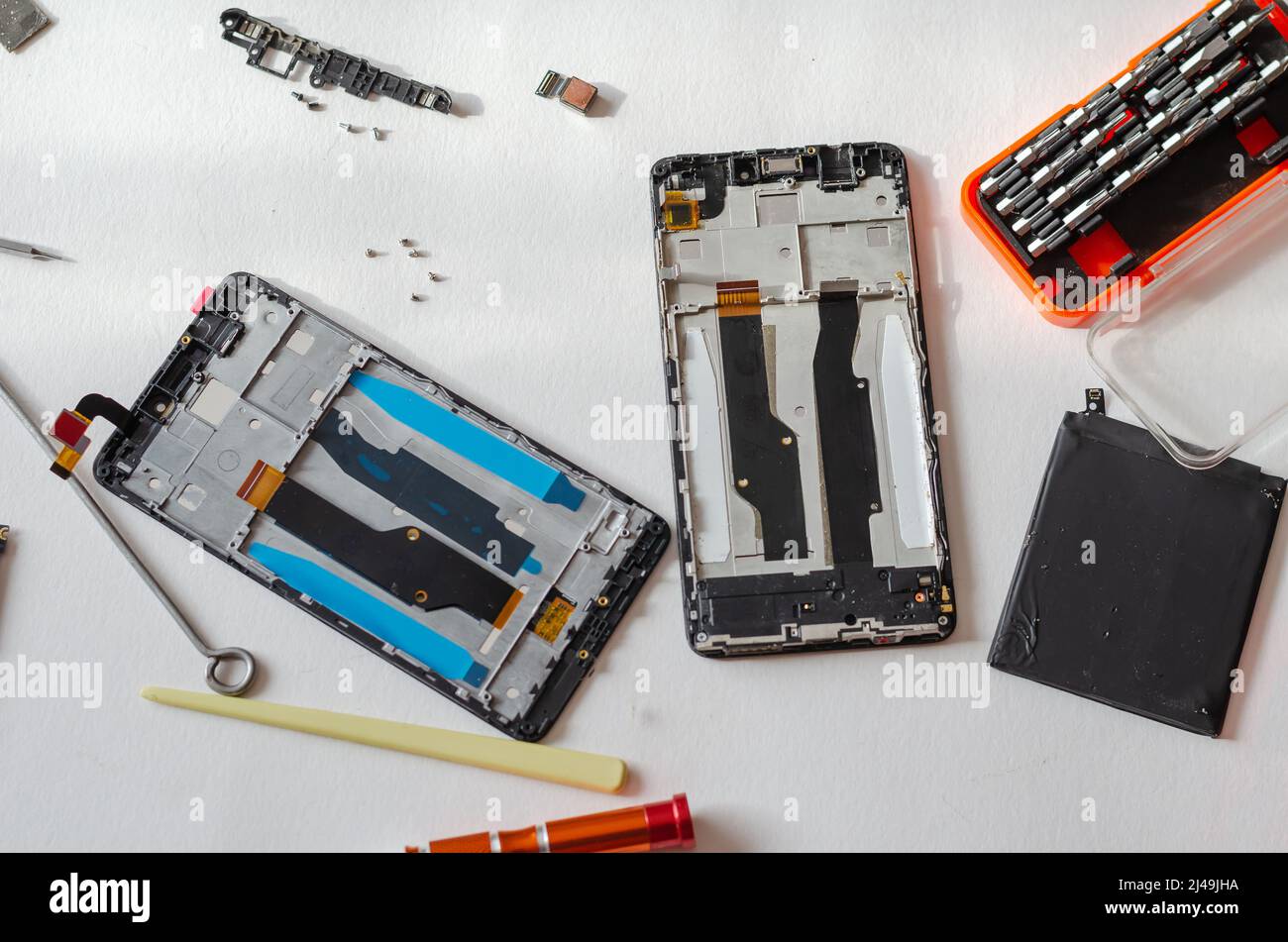Reparatur von Smartphones Konzept. Handwerkzeug und zerlegtes Telefon liegen auf dem Tisch. Teil einer Serie. In Innenräumen. Selektiver Fokus. Stockfoto