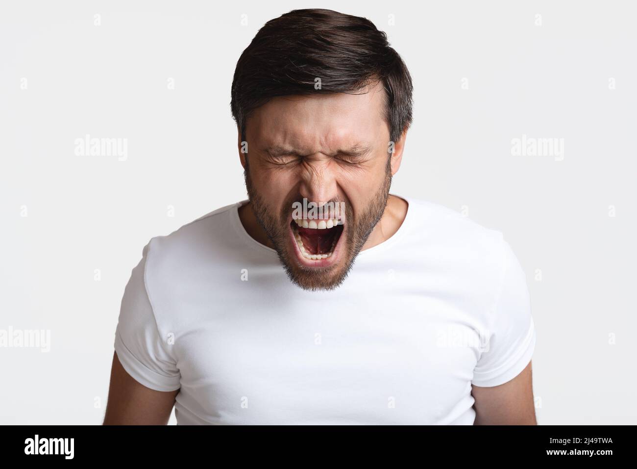 Mad Male Schrie Laut Vor Wut Mit Geschlossenen Augen, Studio Stockfoto