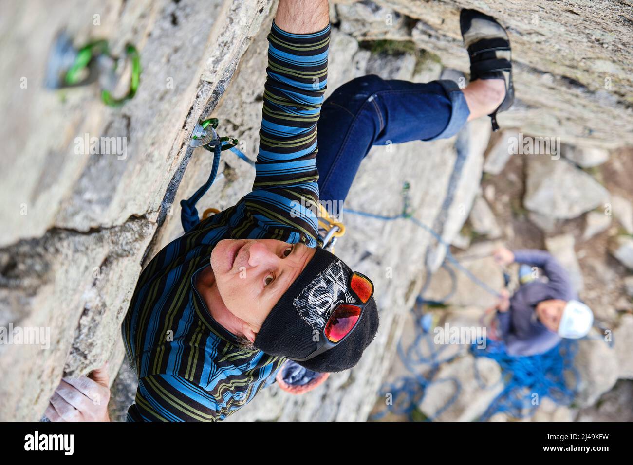 Ein reifer Kletterfelsen klettert auf eine steile Klippe Stockfoto