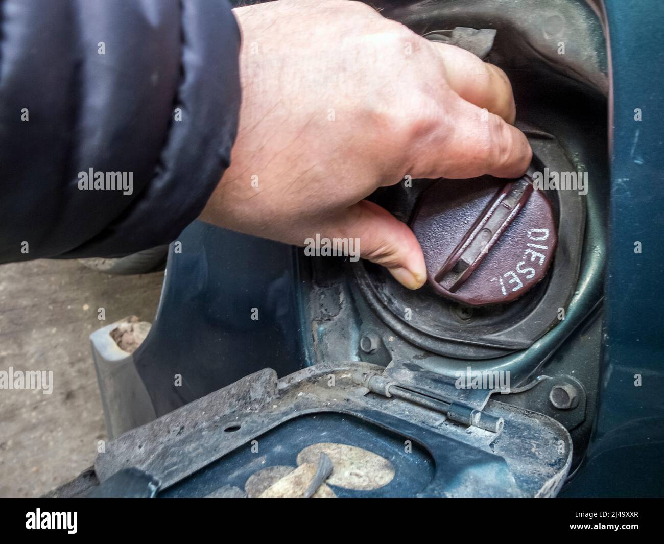 Ein englischer Tankstellenkunde mit einem alten Diesel-Van ersetzt den Tankdeckel, nachdem er Dieselkraftstoff gekauft und den Deckel wieder aufgeschraubt hat. Japanisch Stockfoto