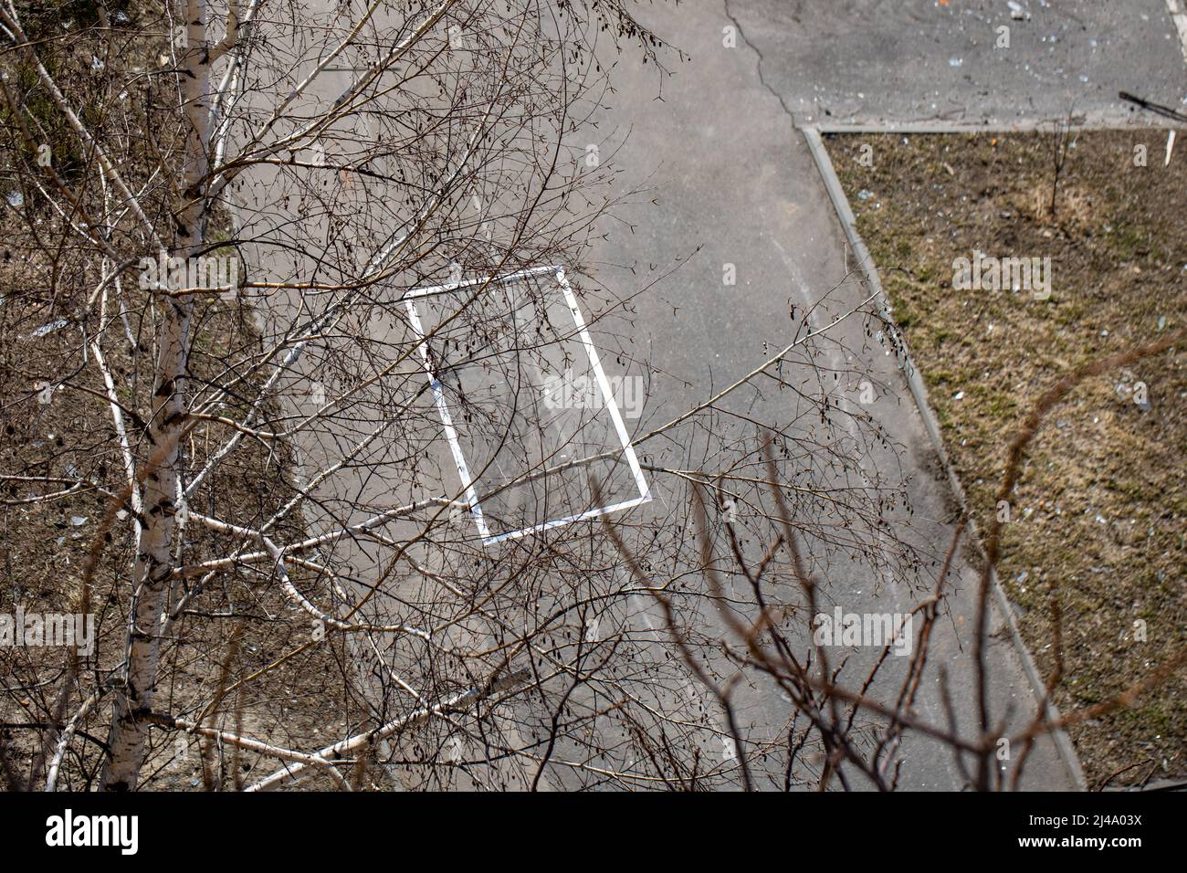 Teile der Fenster hängen an Ästen und liegen auf dem Boden. Die Luftwaffe der russischen Armee bombardierte zivile Objekte. Raketenangriff. Krieg Russlands Stockfoto