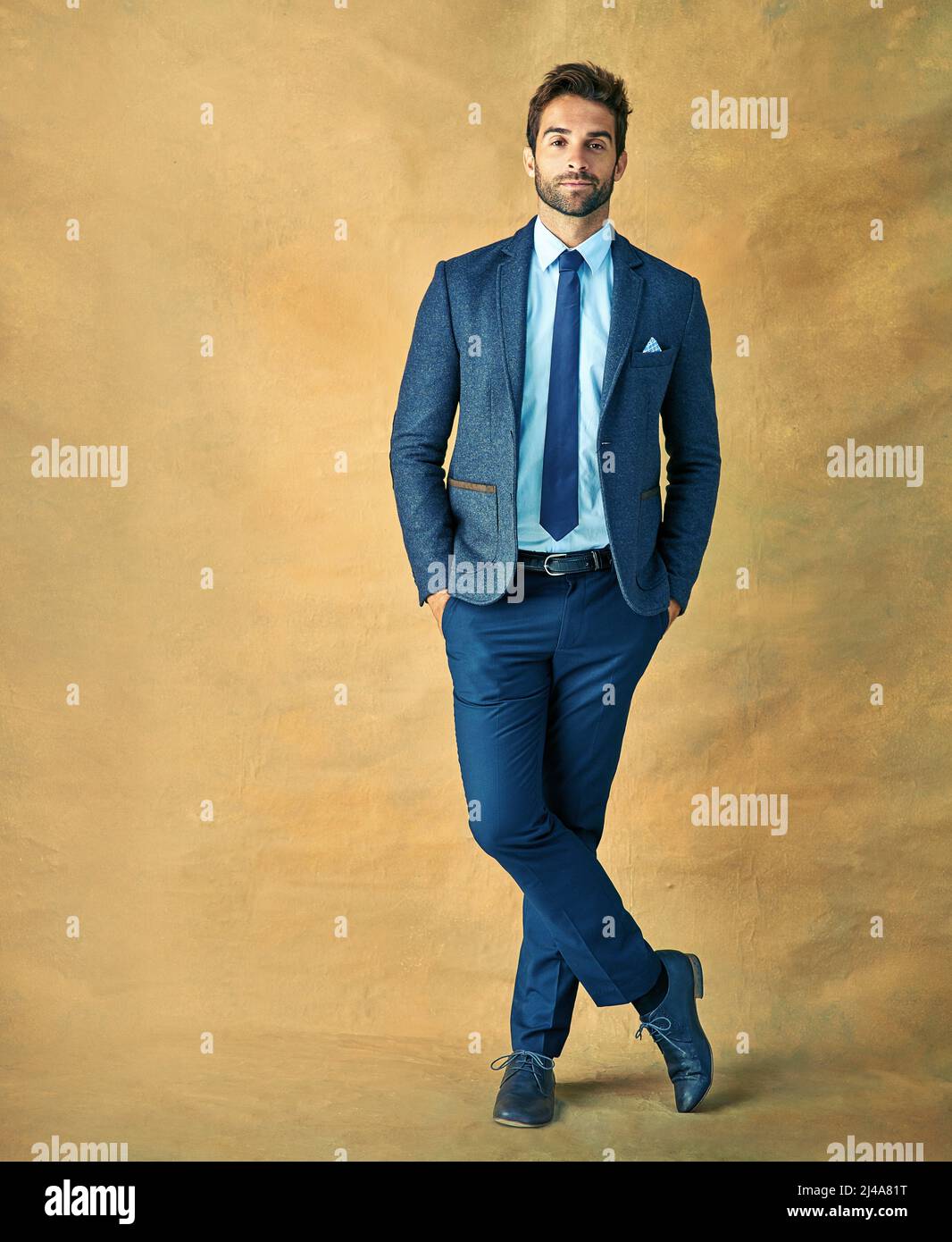 Der Erfolg ist golden. Studioaufnahme eines hübschen jungen Geschäftsmannes, der vor goldenem Hintergrund posiert. Stockfoto