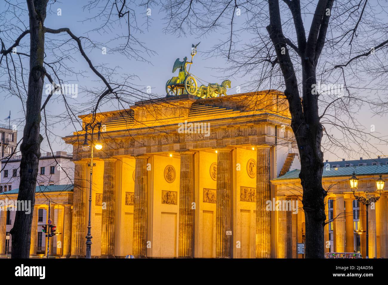 Das Brandenburger Tor in Berlin im Morgengrauen durch einige Bäume gesehen Stockfoto