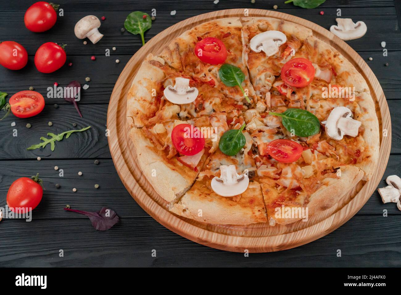 Pizza mit Mozzarella-Käse, mit Pilzen, Tomaten, Kräutern und Pfefferoni-Gewürzen. Stockfoto