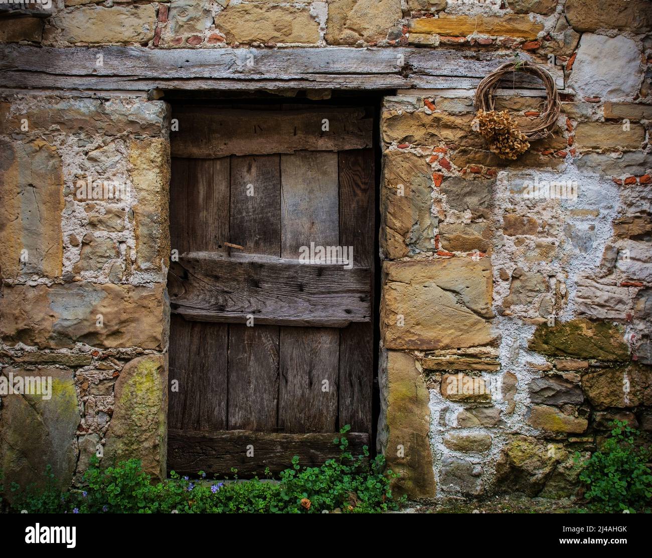 Eine alte Holztür in einem verrottten Haus in Poffabro, einem historischen mittelalterlichen Dorf im Val Colvera Tal in der Provinz Pordenone, Friaul, Italien Stockfoto