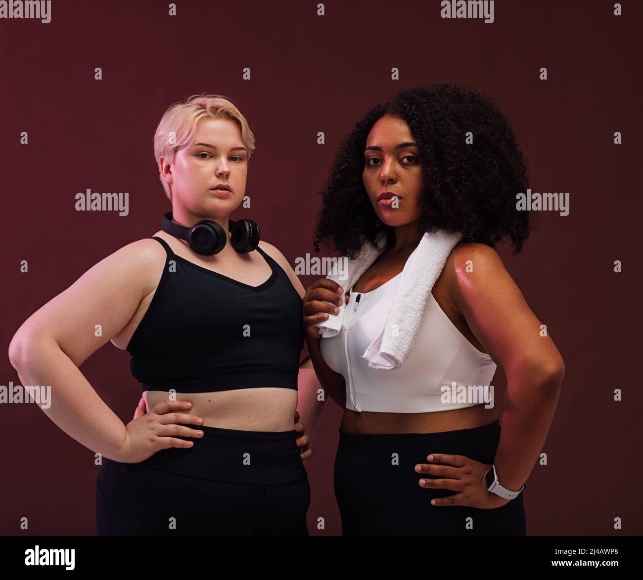 Selbstbewusste Weibchen mit plus-size Körpern, die im Studio zusammenstehen und die Kamera betrachten Stockfoto Selbstbewusste Weibchen mit plus-size Körpern, die im Studio zusammenstehen und die Kamera betrachten Stockfoto