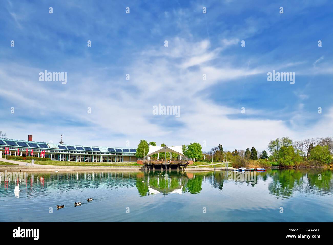 Freiburg, Deutschland - April 2022: 'Seegpark' mit kleiner Freiluftbühne am See Stockfoto