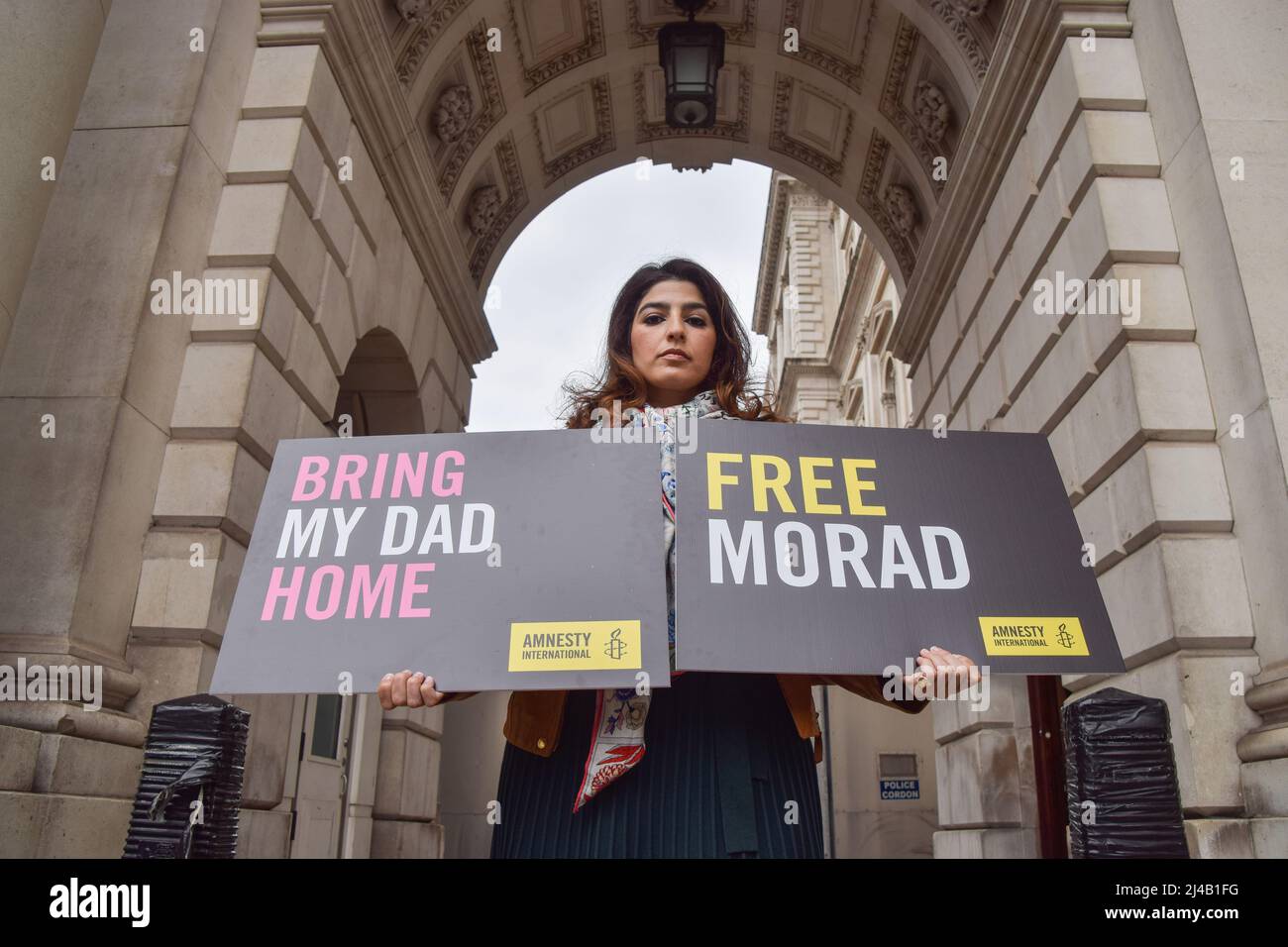 London, Großbritannien. 13. April 2022. Roxanne Tahbaz hält während des Protestes Plakate mit dem Titel „Bring My Dad Home“ und „Free Morad“. Roxanne Tahbaz veranstaltete einen Protest mit Amnesty International vor dem Außen-, Commonwealth- und Entwicklungsbüro in Westminster und forderte die britische Regierung auf, ihre Bemühungen zu verstärken, ihren Vater Morad Tahbaz nach Hause zu holen. Morad, ein Naturschützer und US- und britischer Staatsbürger mit iranischem Familienhintergrund, ist seit mehr als vier Jahren willkürlich im Iran inhaftiert. (Foto: Vuk Valcic/SOPA Images/Sipa USA) Quelle: SIPA USA/Alamy Live News Stockfoto