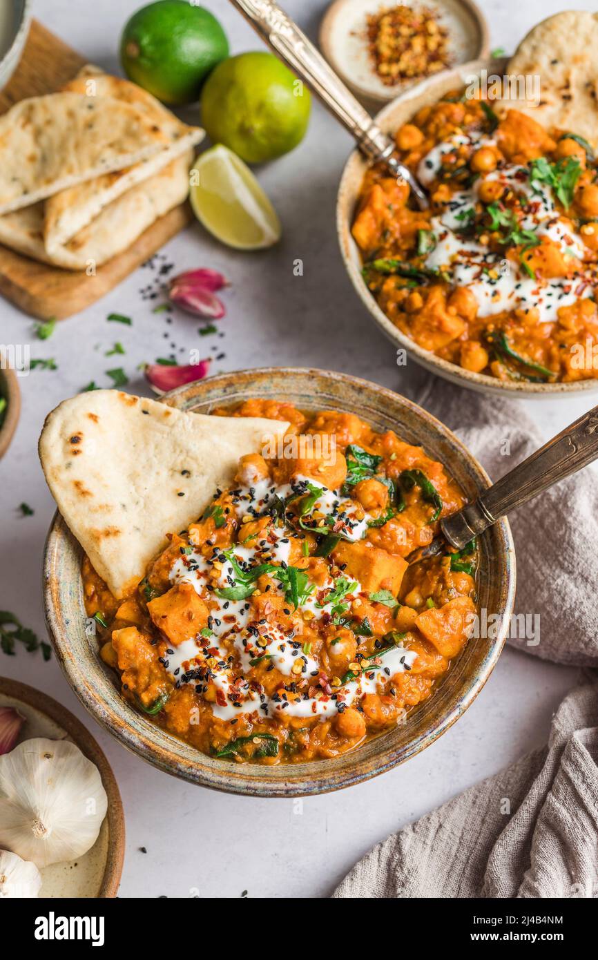 Süßkartoffeln und Spinat-Nocken in einer Schüssel mit Naan-Brot Stockfoto