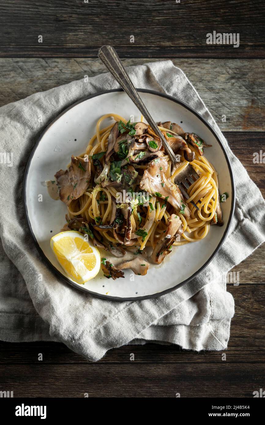 Cremige Pasta mit knusprigen Pilzen auf einem Holzhintergrund Stockfoto