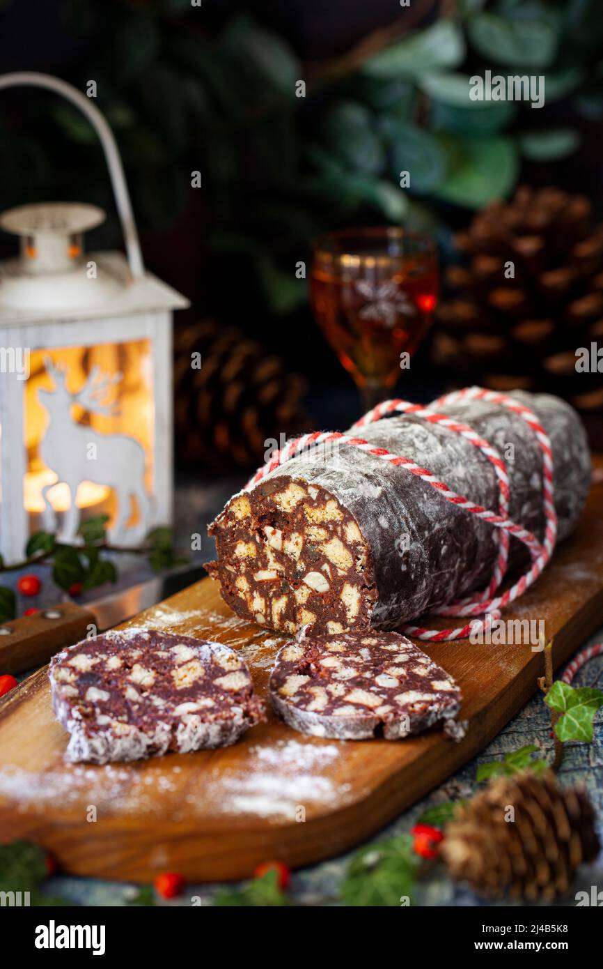 Ein Teil in Scheiben geschnittene Schokoladensalami auf einem Holzbrett. Stockfoto