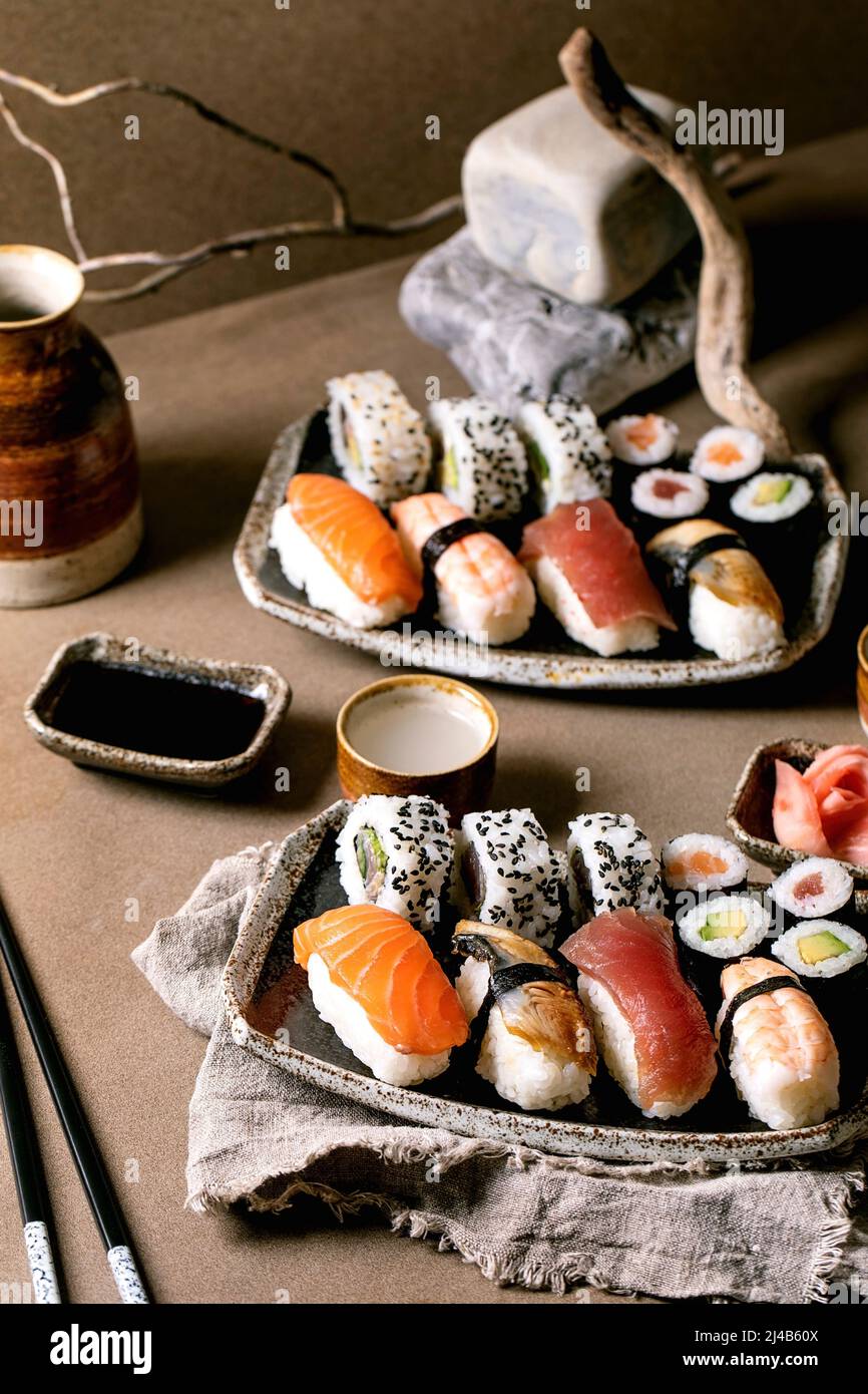 Sushi-Brötchen für zwei Personen. Traditionelles japanisches Sushi und Brötchen mit frischem Lachs, Thunfisch, Aal und Garnelen auf Reis. Auf Tellern mit Sojasauce A servieren Stockfoto