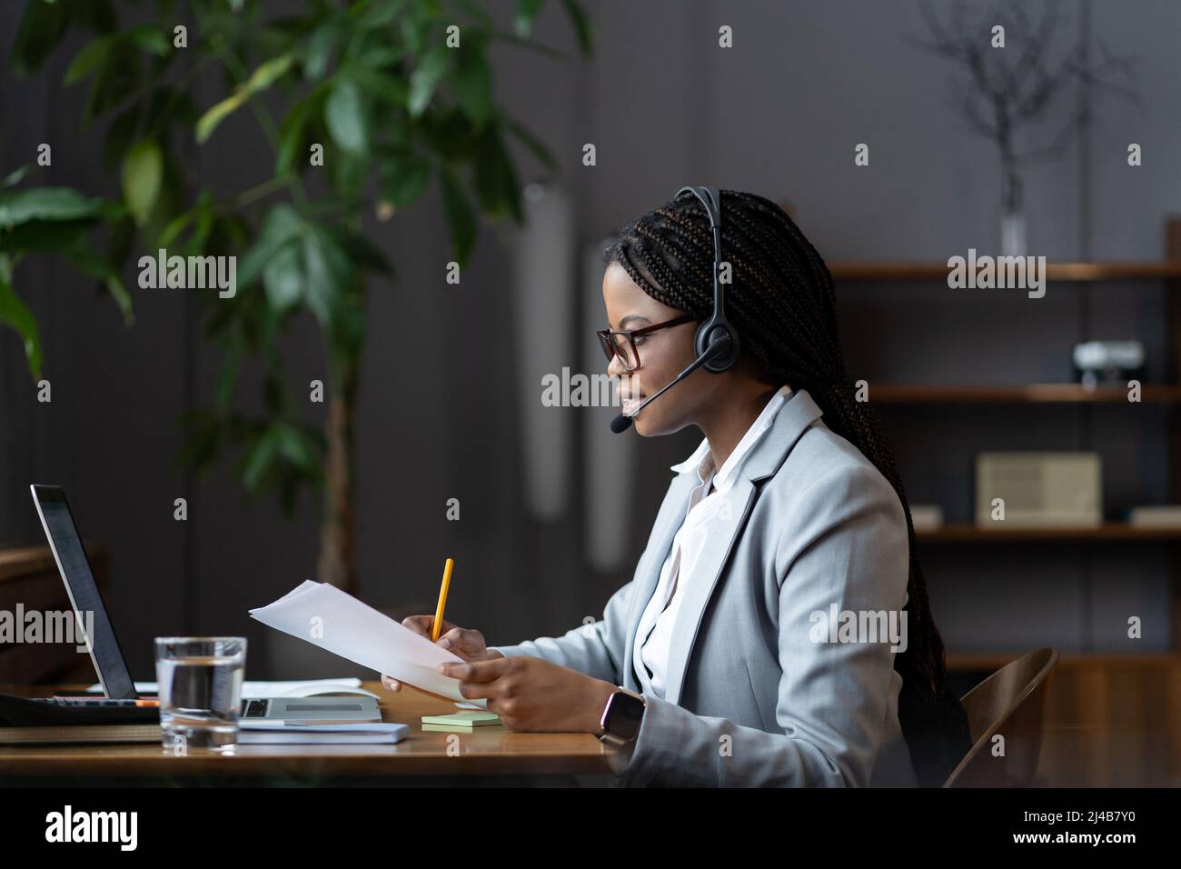 Junge afroamerikanische Frau, Spezialist für Remote-Kundenservice für Headsets, die von zu Hause aus arbeiten Stockfoto