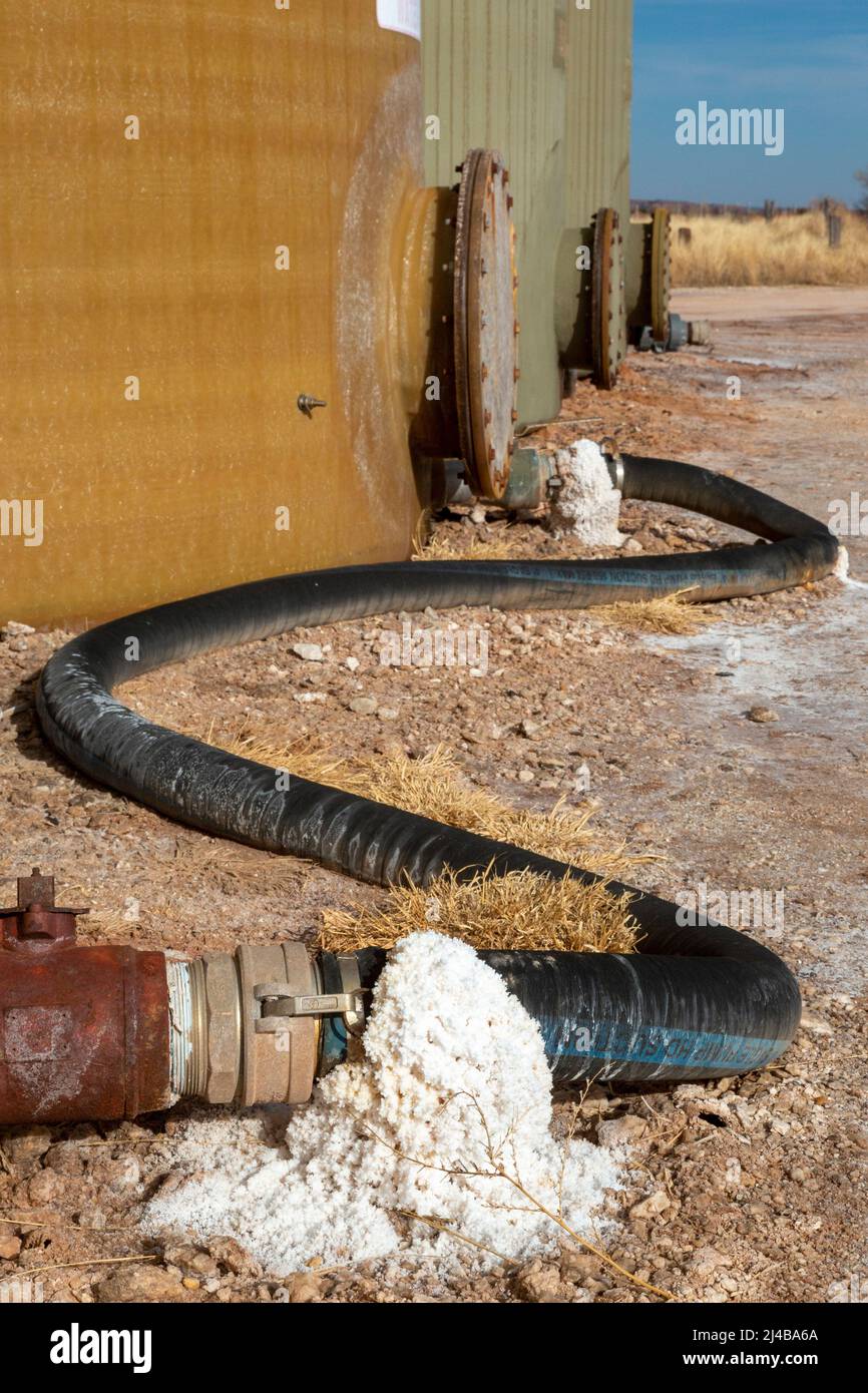 Freedom, Oklahoma - Salzkristalle um Schläuche, die mit Tanks verbunden sind, die schweres Salzwasser enthalten. Sole, auch produziertes Wasser genannt, ist oft ein Nebenproduk Stockfoto