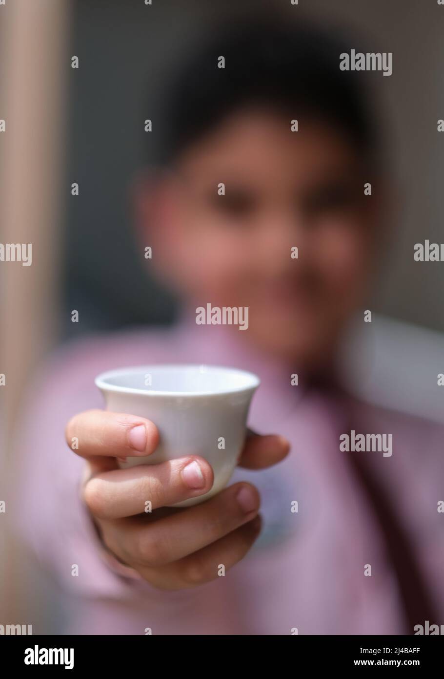 Bokeh Foto des Jungen trägt eine Tasse arabischen Kaffee Stockfoto