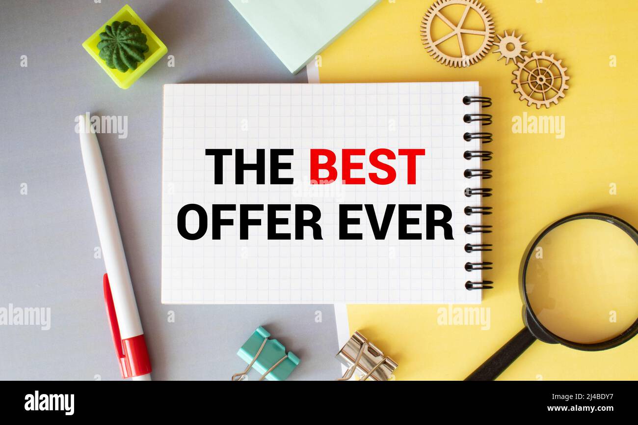 BESTER ANGEBOTSTEXT auf dem Notizblock mit Papierbogen mit Stift und Holzhaus, Stockfoto