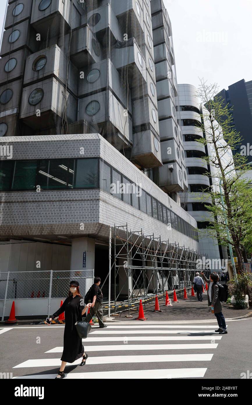 Tokio, Japan. 13. April 2022. Ein Mann fotografiert den Nakagin Capsule Tower, der in Ginza abgerissen wird. Der Rückbau des futuristischen Gebäudes (Wohn- und Büroturm mit Mischnutzung), entworfen vom Architekten Kisho Kurokawa, hat begonnen und besteht aus 144 Einzelkapseln (die alle 25 Jahre ausgetauscht werden müssen). Es wurde zwischen 1970 und 1972 erbaut. Laut lokalen Medien soll der Turm bis Dezember 29 abgerissen werden. (Bild: © Rodrigo Reyes Marin/ZUMA Press Wire) Bild: ZUMA Press, Inc./Alamy Live News Stockfoto