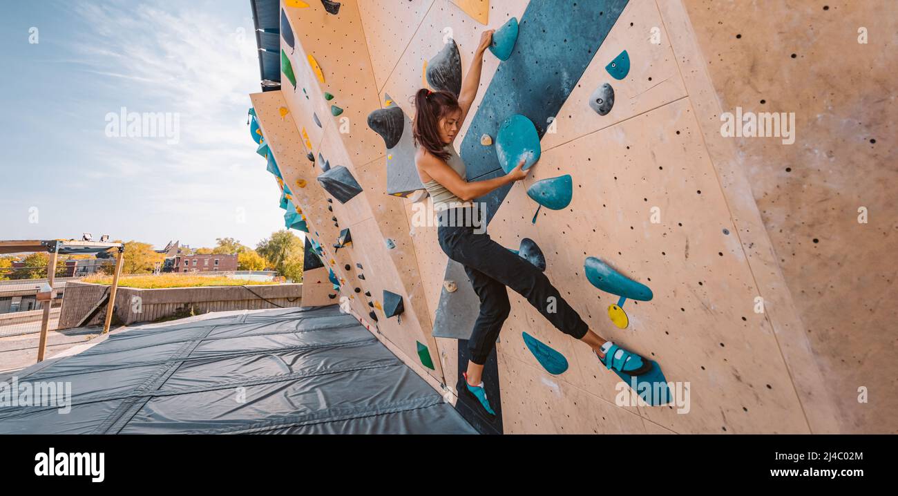 Boulderkletterin Frau, die im Outdoor-Fitnessstudio Boulder Climb Wall Kraft trainiert. Asiatische fit Mädchen gehen nach oben mit Spaß in Extremsport Hobby Stockfoto