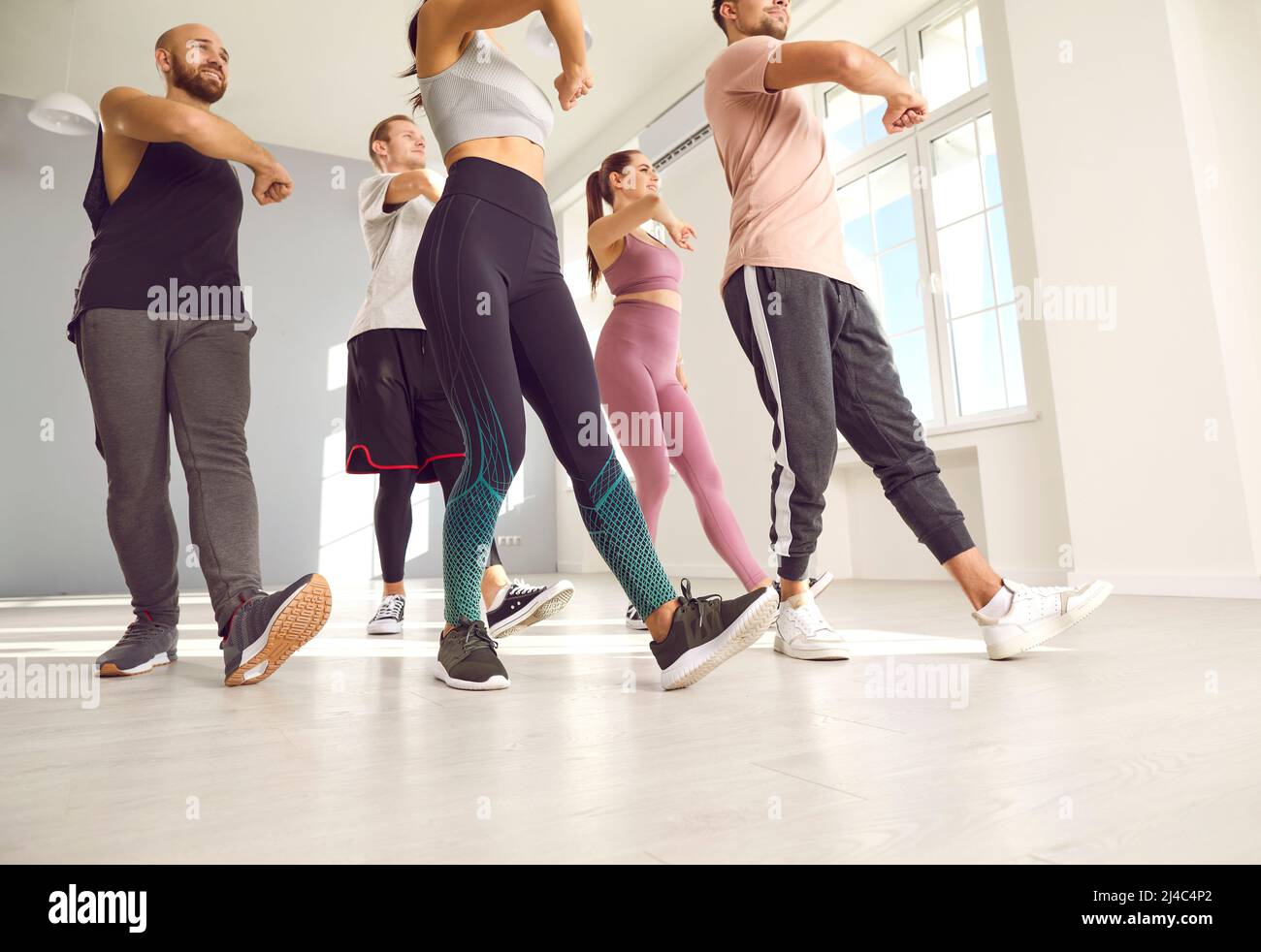 Eine Gruppe von jungen, fit trainingsfreien Menschen, die einen Tanz- oder Fitnesskurs mit einem Trainer absolvieren Stockfoto