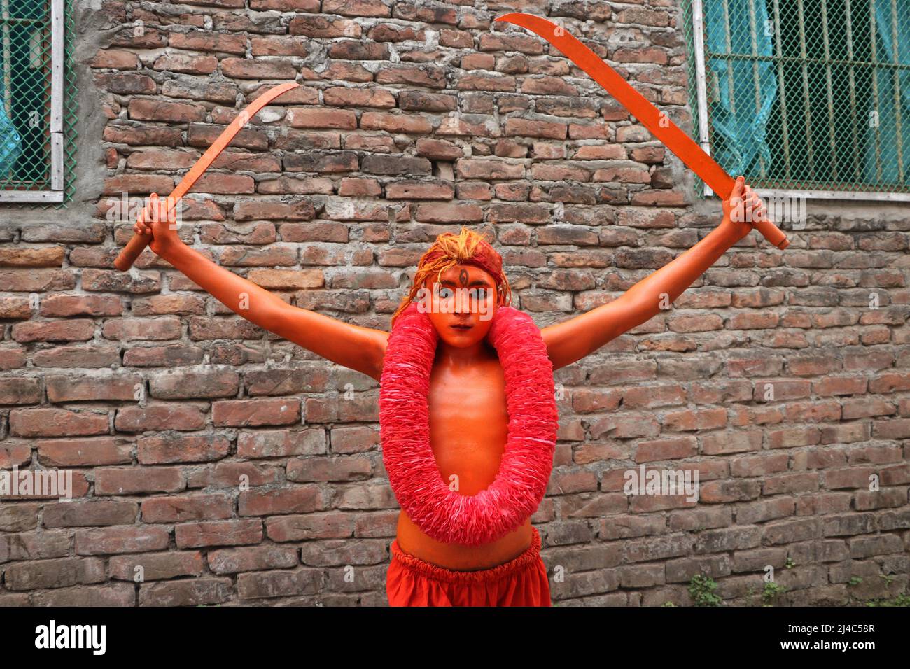 Non Exclusive: MUNSHIGANJ, BANGLADESH - APR 14, 2022: Ein junger Hindu-Anhänger mit seiner in roter Farbe gemalten corp nimmt an einer Prozession Teil Stockfoto