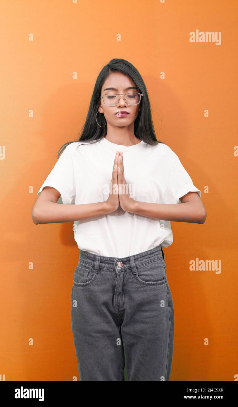 Porträt von geschlossenen Augen Attraktive indische Mädchen oder Frau, die Yoga praktiziert, in Namaste Pose über einem isolierten Hintergrund. Stockfoto