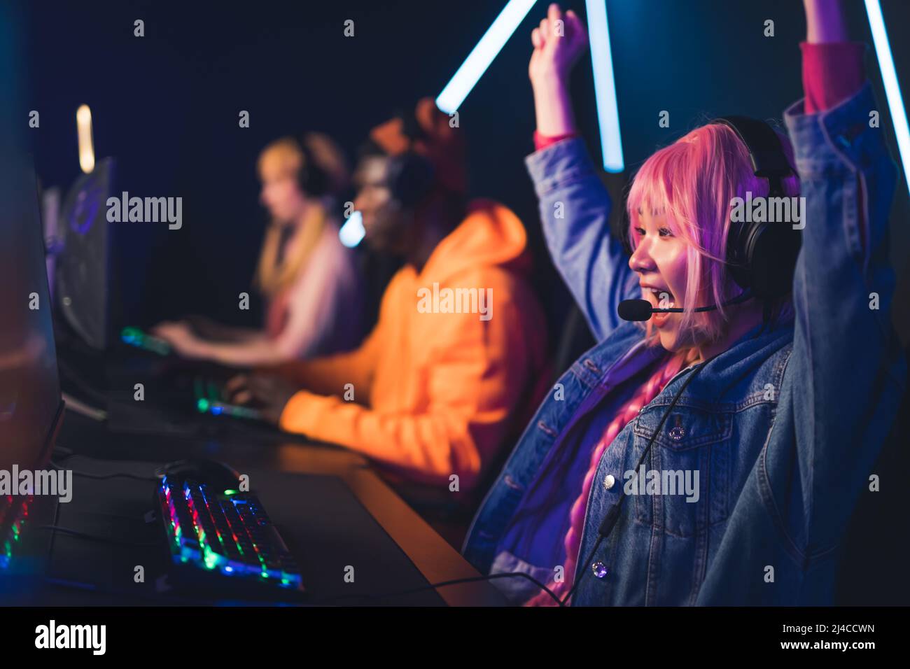 Mädchen mit rosa Haaren gewinnen Online-Videospiel Cyber Sport Konzept neon Farben mittel Nahaufnahme drinnen. Hochwertige Fotos Stockfoto