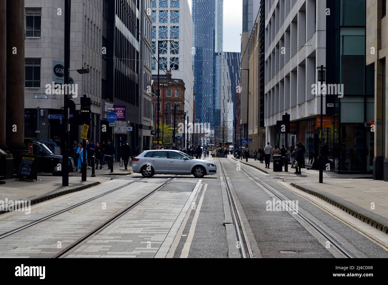 MANCHESTER. GREATER MANCHESTER. ENGLAND. 04-10-22. Mosley Street im Stadtzentrum mit Blick auf den Petersplatz. Ein Auto überquert die Straßenbahnschienen. Stockfoto