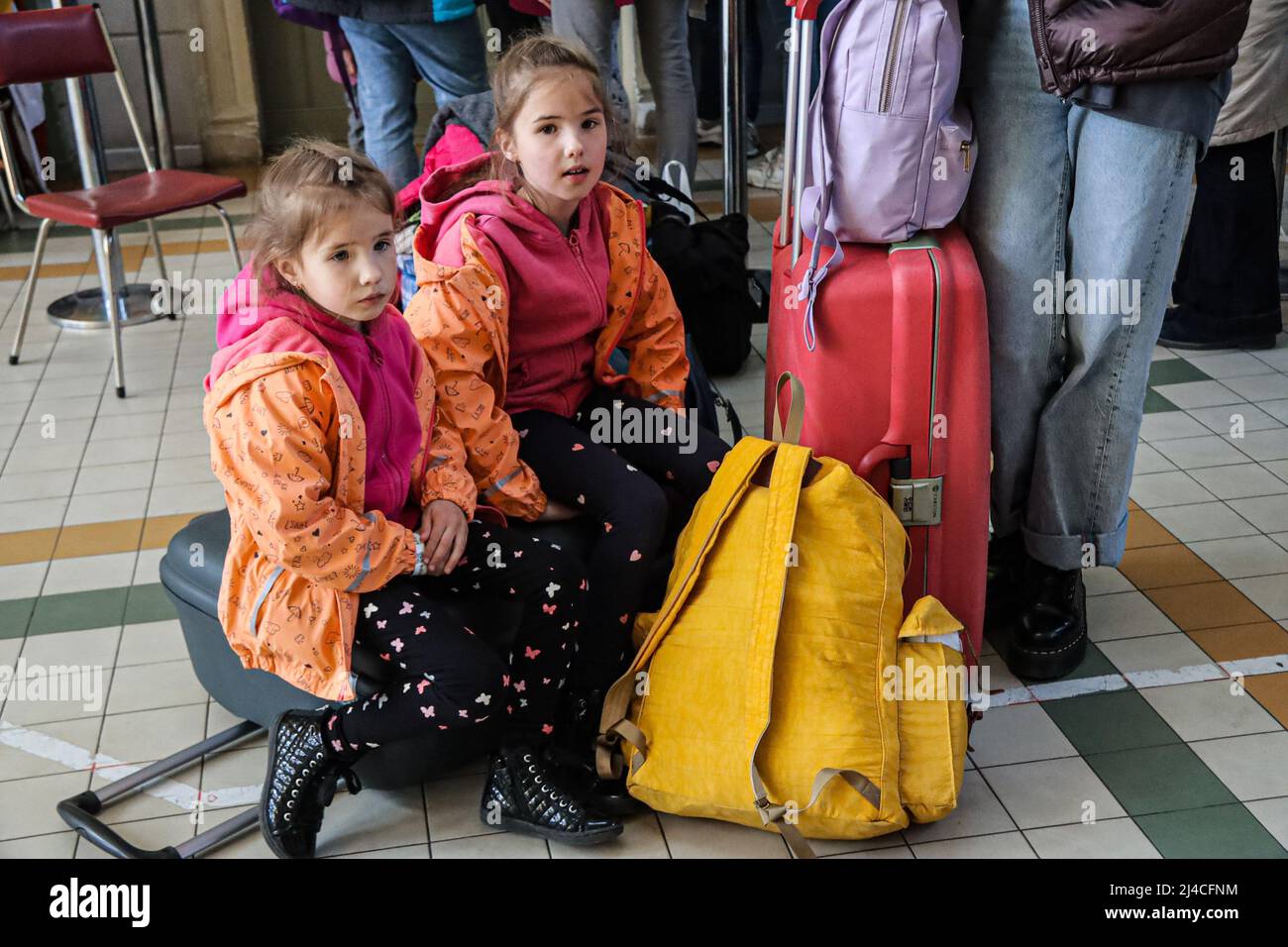 Przemysl, Polen. 13. April 2022. Zwei wunderschöne ukrainische Flüchtlingsschwestern im Alter von 6 und 7 Jahren, die in orange und rosa Kostümen geflossen sind, aus der Ukraine. Sie warten auf einen Zug nach Warschau mit ihrer Mutter, wo sie Zuflucht suchen, bis es sicher ist, in ihre Heimat zurückzukehren. (Bild: © Amy Katz/ZUMA Press Wire) Bild: ZUMA Press, Inc./Alamy Live News Stockfoto