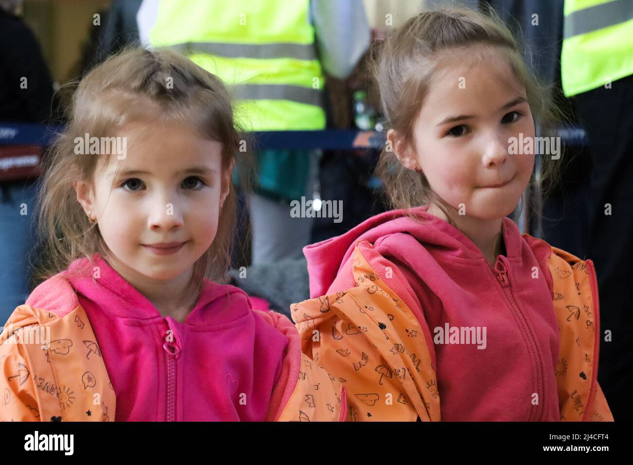 Przemysl, Polen. 13. April 2022. Zwei wunderschöne ukrainische Flüchtlingsschwestern im Alter von 6 und 7 Jahren, die in orange und rosa Kostümen geflossen sind, aus der Ukraine. Sie warten auf einen Zug nach Warschau mit ihrer Mutter, wo sie Zuflucht suchen, bis es sicher ist, in ihre Heimat zurückzukehren. (Bild: © Amy Katz/ZUMA Press Wire) Bild: ZUMA Press, Inc./Alamy Live News Stockfoto