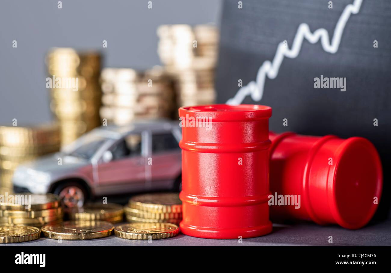 Rote Fässer und Autos, Geldstapel und eine steigende Kurve, die sehr hohe Kraftstoffpreise symbolisiert Stockfoto