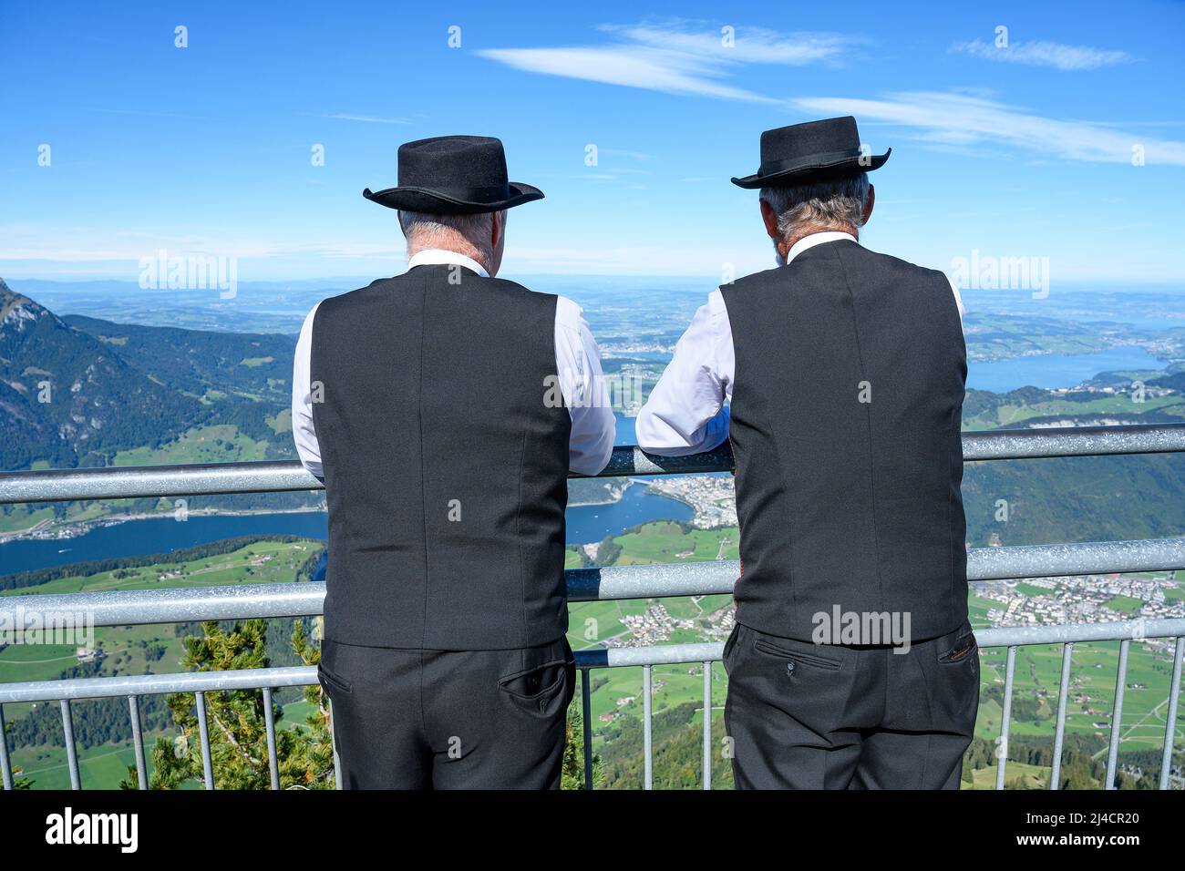 Zwei Männer in traditionellen Sängerkostümen genießen den Blick auf das Stanserhorn, Kanton Nidwalden, Schweiz Stockfoto