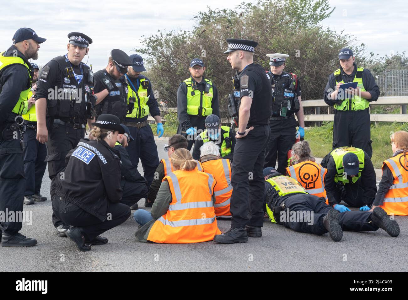 Thurrock, Essex, Großbritannien 13. April 2022 Just Stop Oil Demonstranten blockieren einen großen Kreisverkehr, der an Bord von zwei Tankern klettert, während sich mehrere Demonstranten an die Straße kleben. Alle Demonstranten wurden entfernt und verhaftet. Stockfoto