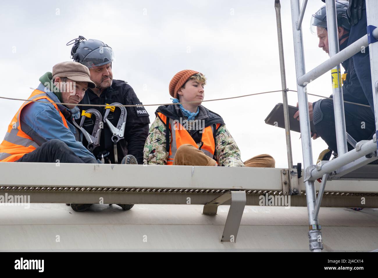 Thurrock, Essex, Großbritannien 13. April 2022 Just Stop Oil Demonstranten blockieren einen großen Kreisverkehr, der an Bord von zwei Tankern klettert, während sich mehrere Demonstranten an die Straße kleben. Alle Demonstranten wurden entfernt und verhaftet. Stockfoto