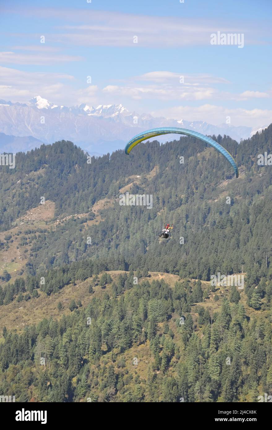 Mandi, Himachal Pradesh, Indien - 10 16 2021: Ein junger Mann genießt Gleitschirmfliegen mit einem professionellen Piloten am Himmel mit Berg- und Gletscherblick Stockfoto