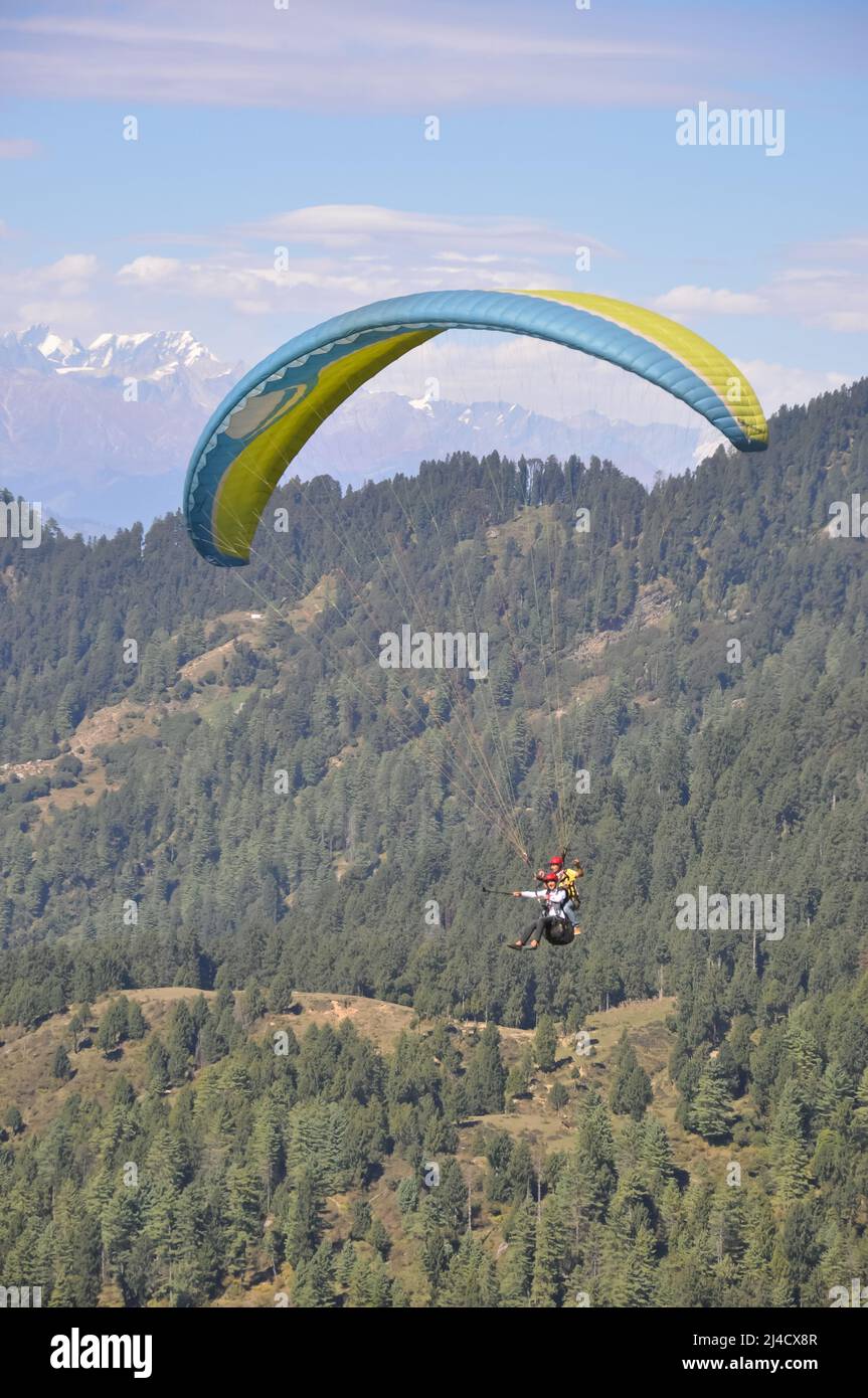 Mandi, Himachal Pradesh, Indien - 10 16 2021: Ein junger Mann genießt Gleitschirmfliegen mit einem professionellen Piloten am Himmel mit Berg- und Gletscherblick Stockfoto