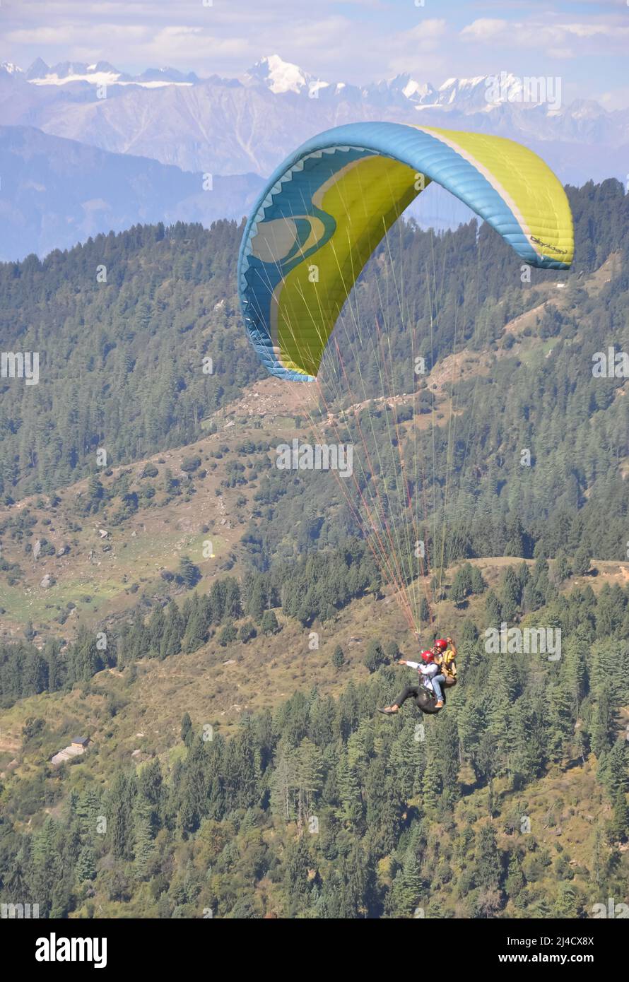Mandi, Himachal Pradesh, Indien - 10 16 2021: Ein junger Mann genießt Gleitschirmfliegen mit einem professionellen Piloten am Himmel mit Berg- und Gletscherblick Stockfoto