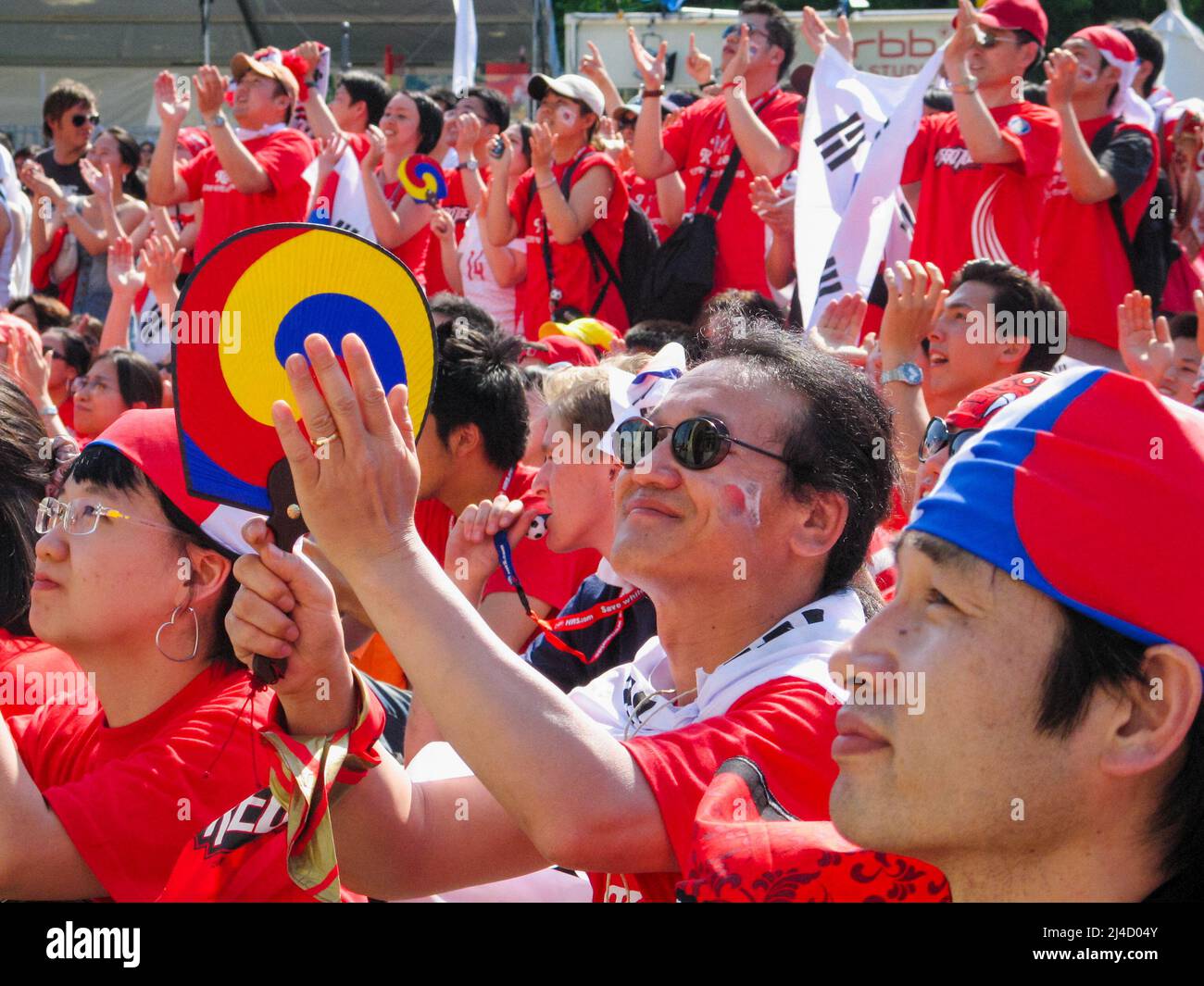 Fußballfans in der Berliner „Fan Mile“-Zone im Brandenburg Park sehen sich das Spiel (Südkorea gegen Togo) während der FIFA Fußball-Weltmeisterschaft 2006 in Deutschland auf der Großleinwand an. 13. Juni 2006, Berlin, Deutschland, Europa. In 12 Gaststädten in ganz Deutschland fanden Fanzonen mit großen Bildschirmen für die öffentliche Betrachtung von Spielen statt, die Millionen Besucher anlockte. Stockfoto