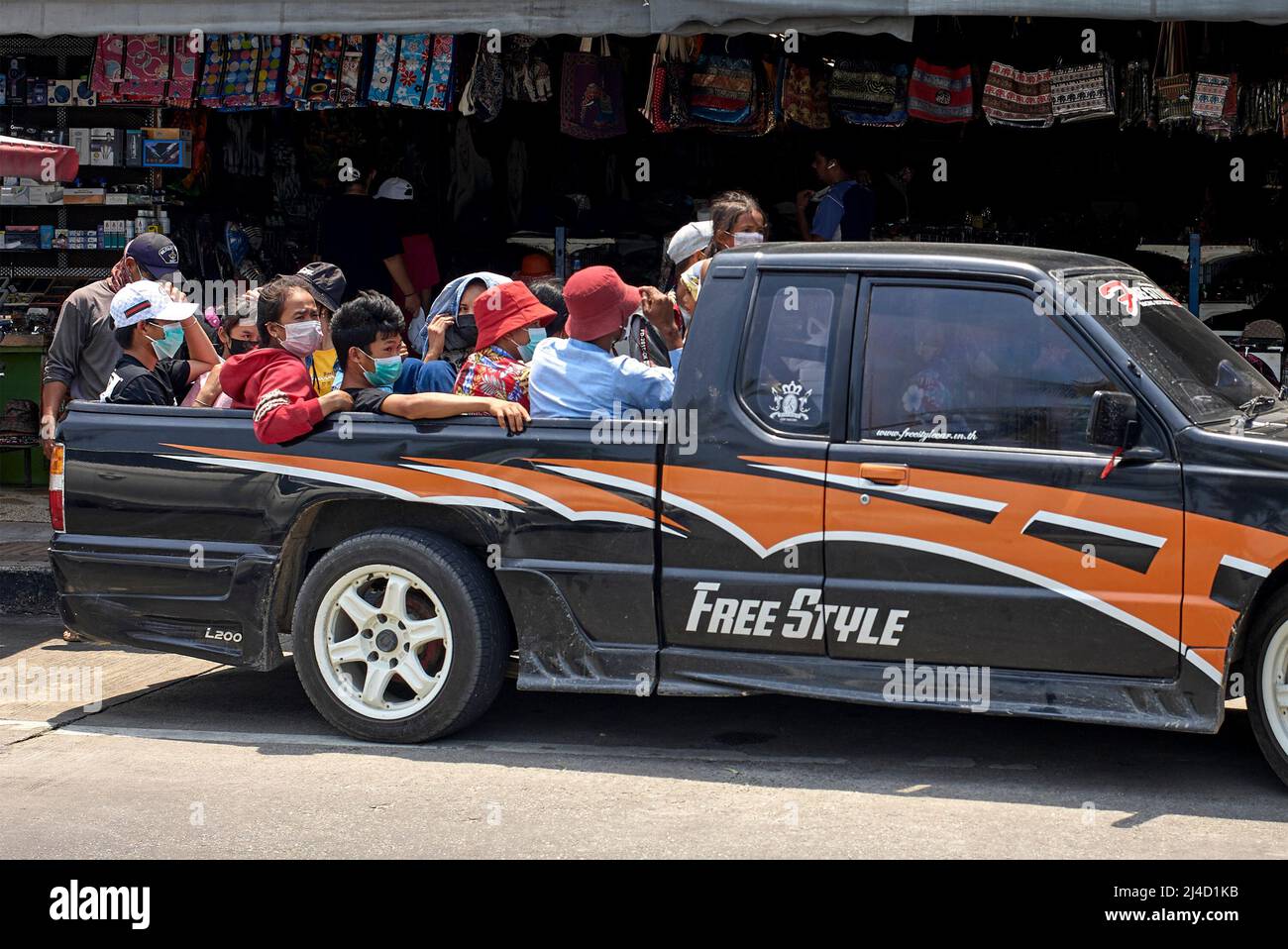 Thailand, Transport von Menschen. Überladenes Fahrzeug. Pickup-LKW voll beladen mit Menschen fahren im Heck. Thailand Südostasien Stockfoto