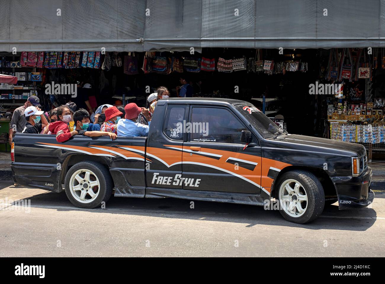 Thailand, Transport von Menschen. Überladenes Fahrzeug. Pickup-LKW voll beladen mit Menschen fahren im Heck. Thailand Südostasien Stockfoto