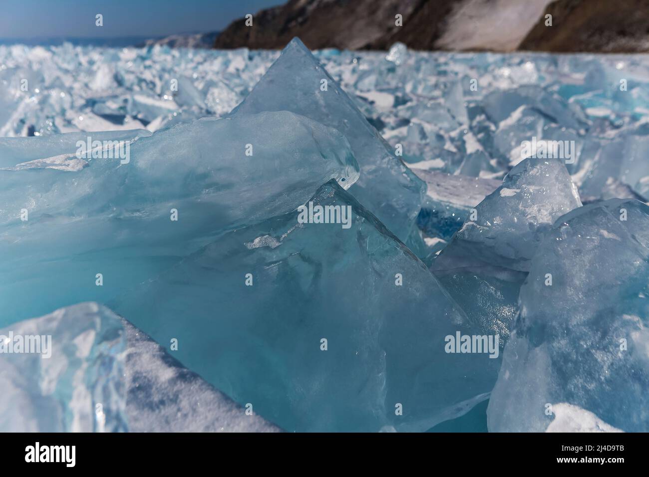 Auf dem idealen glatten Eis des baikals liegende Eisstücke mit Eiswürfeln am Horizont. Die Sonne scheint durch die Seiten der Eiswürfel. Floes sehen aus wie Stockfoto