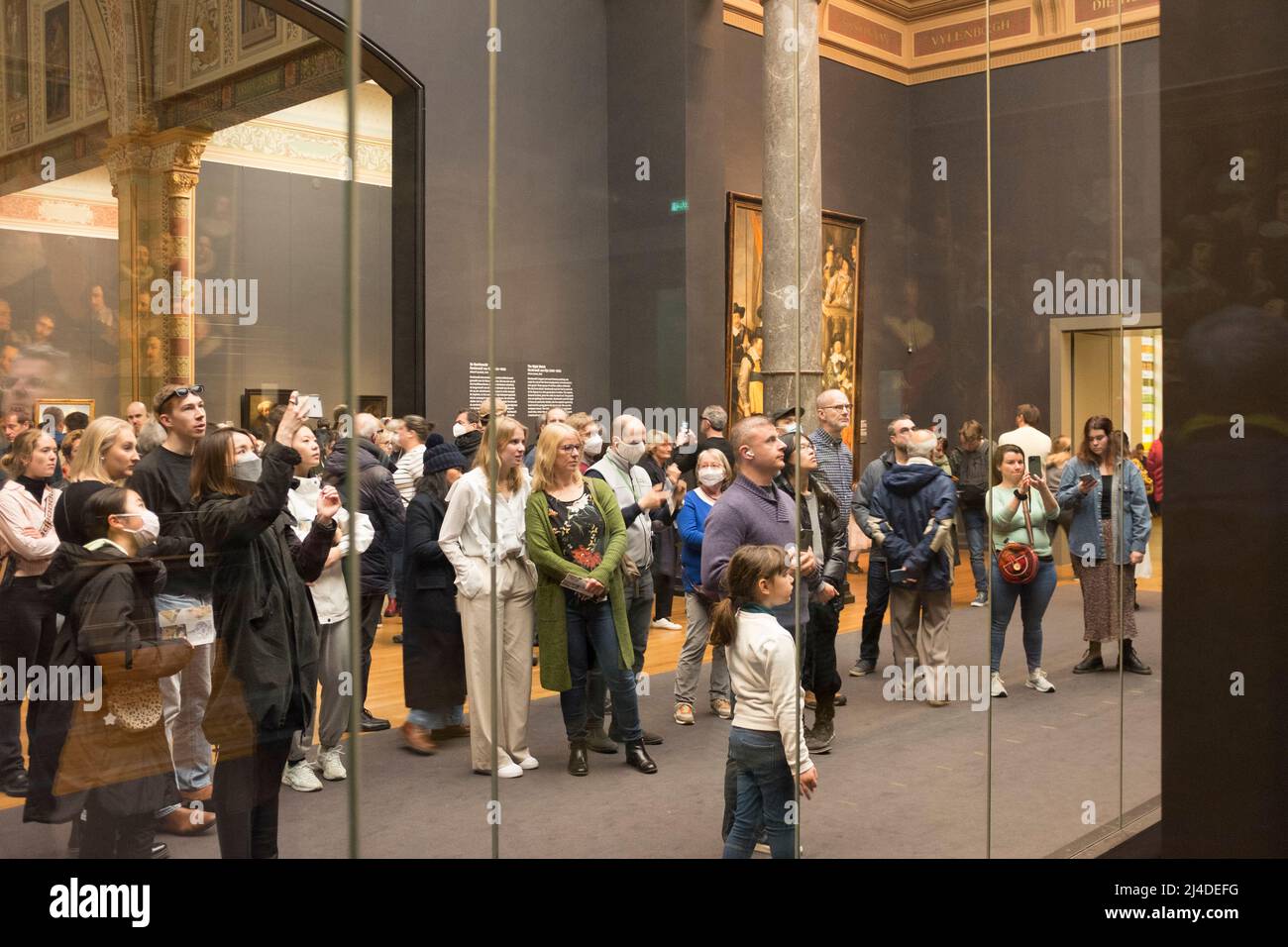 Die Besucher sehen die Nachtwache von Rembrandt hinter ihrem Schutzglas im Rijksmuseum in Amsterdam, Niederlande. Stockfoto