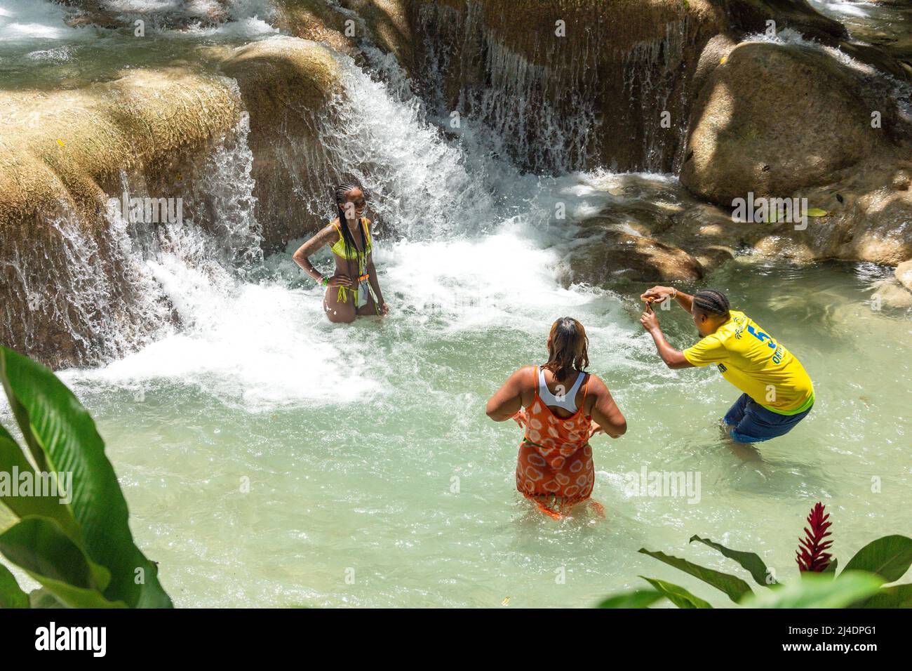 Touristen, die sich an den Dunns River Falls, Ocho Rios, St. Ann Parish, Jamaika, Großantillen, Karibik Stockfoto